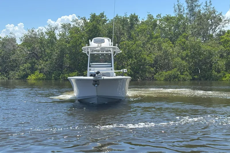  Yacht Photos Pics 2020 Sportsman Open 282 Center Console boat navigating through calm waters near lush greenery.