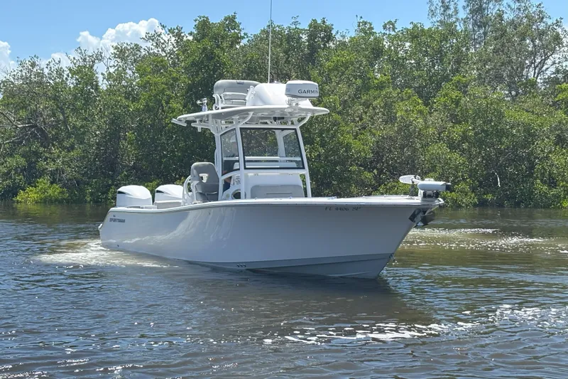  Yacht Photos Pics 2020 Sportsman Open 282 Center Console boat on calm water, surrounded by lush greenery.
