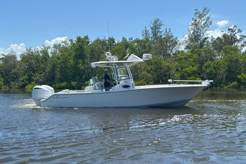  Yacht Photos Pics 2020 Sportsman Open 282 Center Console boat cruising on a sunny day near lush greenery.