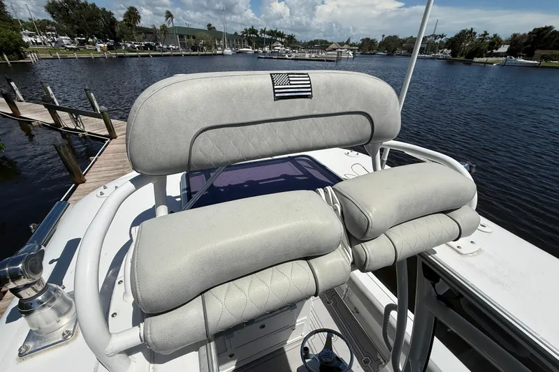  Yacht Photos Pics 2020 Sportsman Open 282 Center Console boat with cushioned seating, docked by a scenic waterfront.