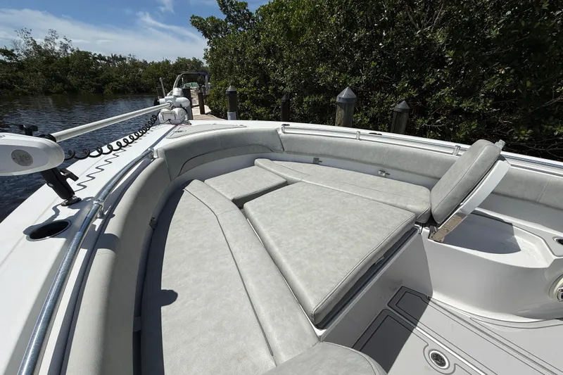  Yacht Photos Pics 2020 Sportsman Open 282 Center Console boat with cushioned seating, docked by lush greenery.
