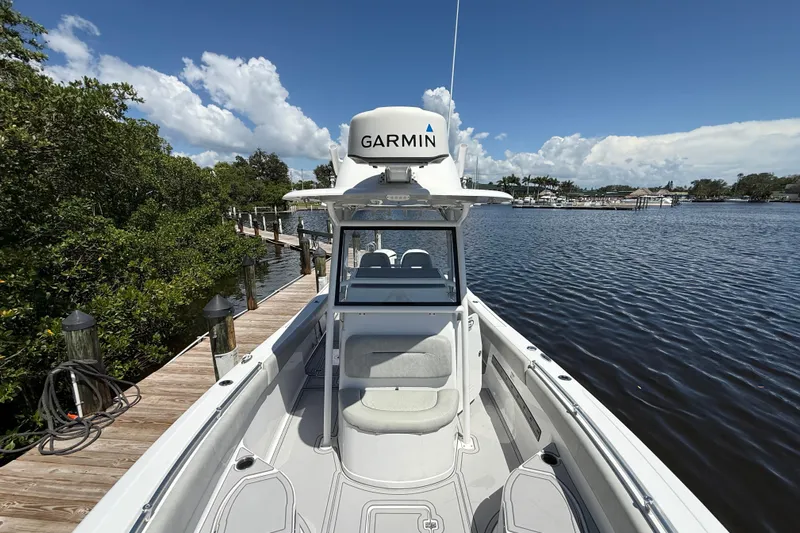  Yacht Photos Pics 2020 Sportsman Open 282 Center Console boat docked by a scenic waterfront.
