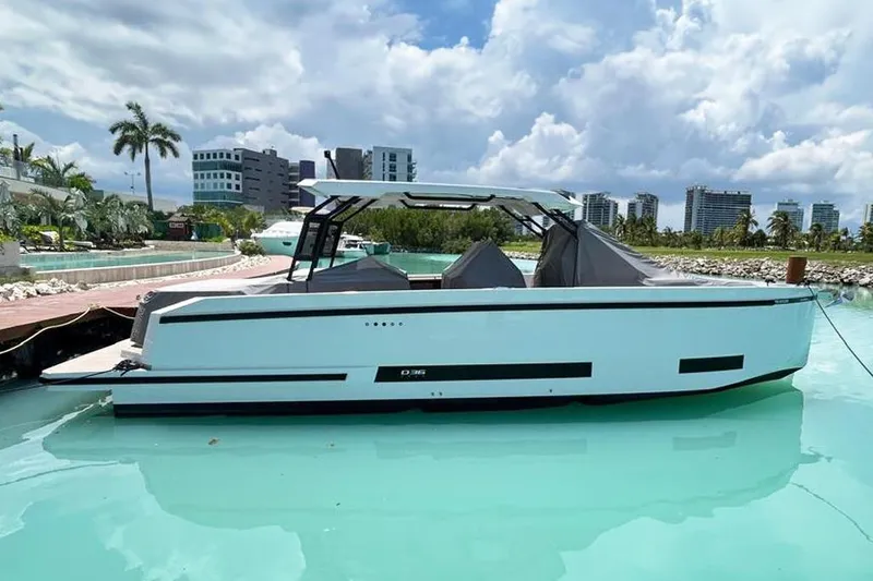 2025 Day 36 @ Cancun Yacht Photos Pics 2025 De Antonio Yachts D36 in marina, modern design, clear blue water, urban skyline backdrop.