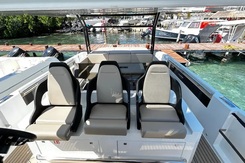 2025 Day 36 @ Cancun Yacht Photos Pics 2025 DeAntonio Yachts D36 cockpit with three modern seats, docked by clear water.