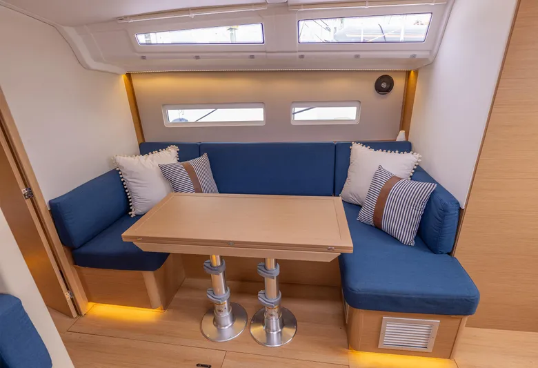  Yacht Photos Pics Interior of 2020 Jeanneau Sun Odyssey 410 with blue seating and wooden table.
