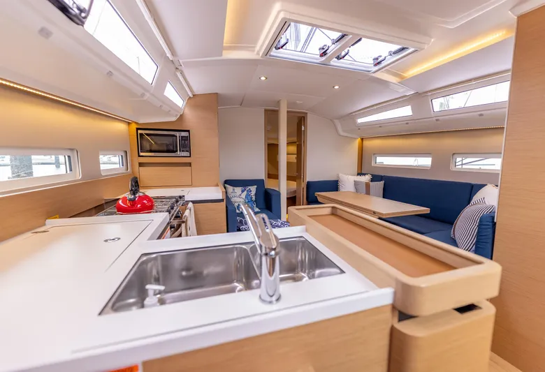 Yacht Photos Pics Modern interior of 2020 Jeanneau Sun Odyssey 410 yacht with kitchen and seating area.