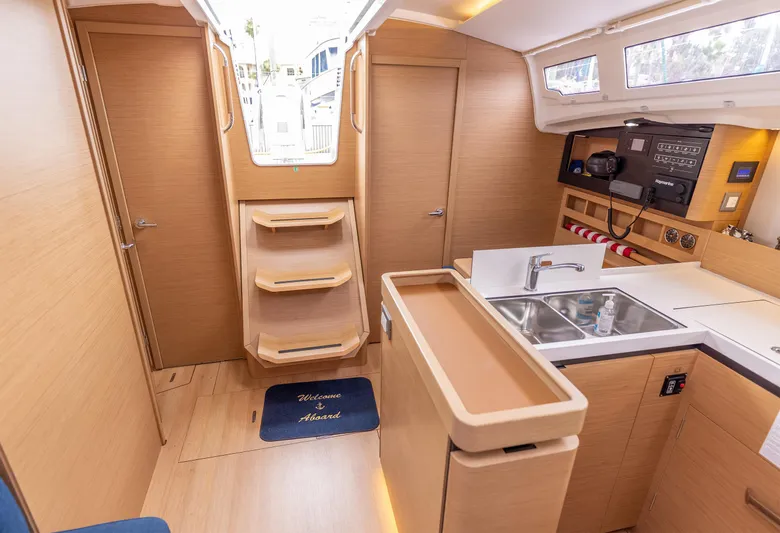  Yacht Photos Pics Interior of 2020 Jeanneau Sun Odyssey 410 sailboat with modern kitchen and wooden finish.