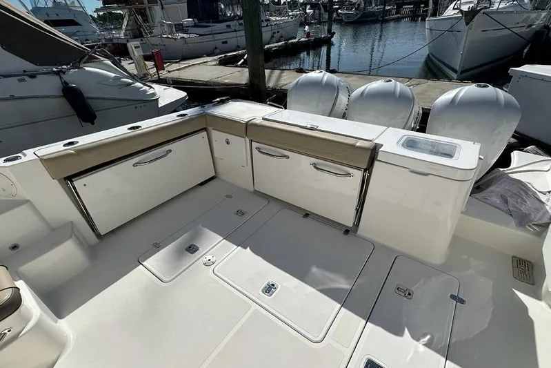 Wave Paver Yacht Photos Pics 2020 Pursuit OS 355 Offshore boat deck with storage compartments and outboard motors.