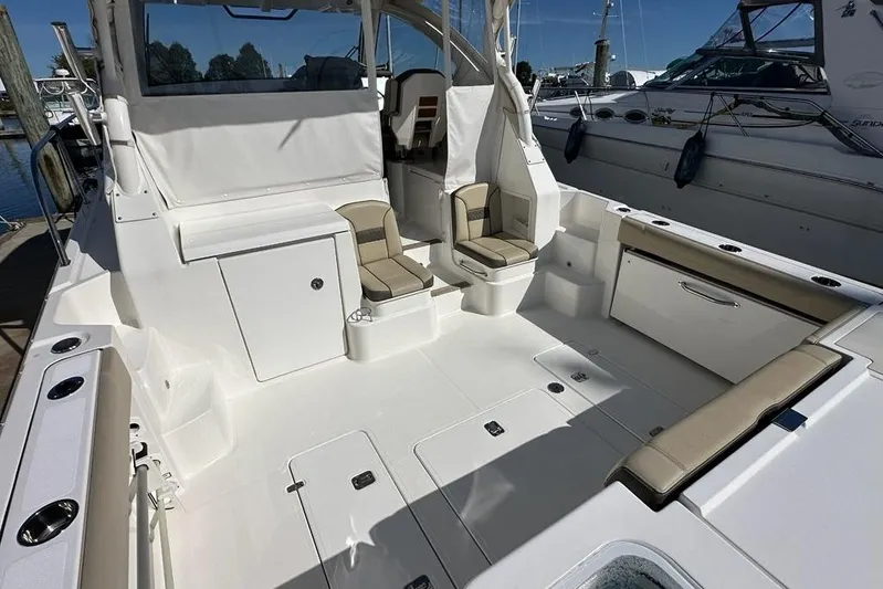 Wave Paver Yacht Photos Pics 2020 Pursuit OS 355 Offshore boat interior with seating and storage, docked at marina.
