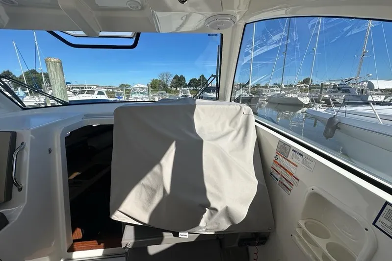 Wave Paver Yacht Photos Pics 2020 Pursuit OS 355 Offshore boat interior with covered seat, docked at marina.