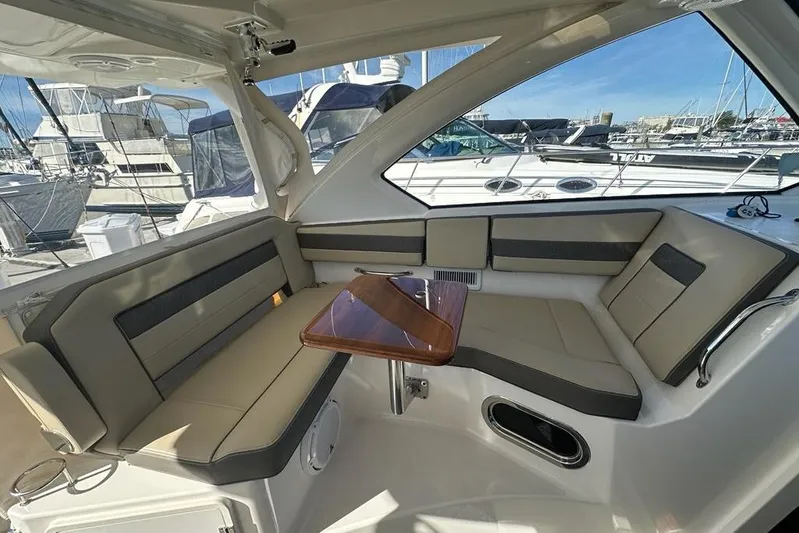 Wave Paver Yacht Photos Pics 2020 Pursuit OS 355 Offshore boat interior with cushioned seating and wooden table.
