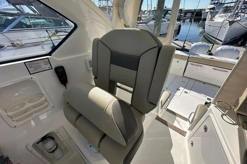 Wave Paver Yacht Photos Pics 2020 Pursuit OS 355 Offshore boat interior with helm seat and marina view.