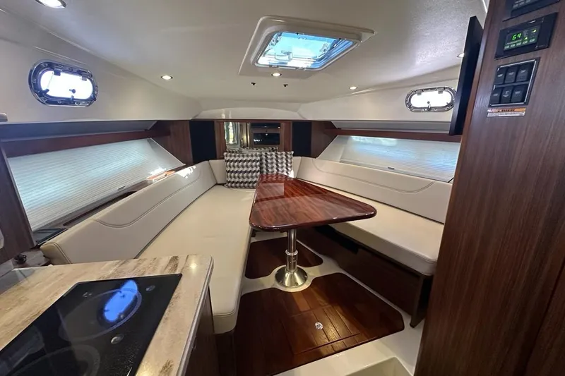 Wave Paver Yacht Photos Pics Luxurious interior of 2020 Pursuit OS 355 Offshore yacht with elegant seating and wooden table.