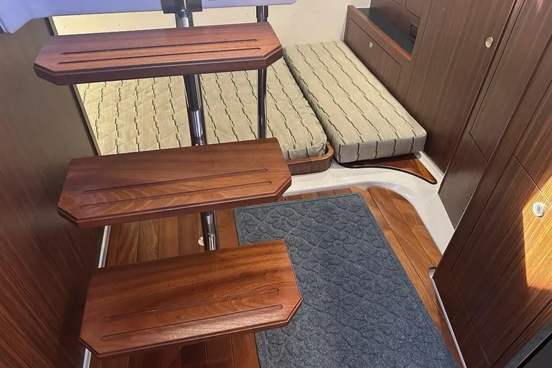 Wave Paver Yacht Photos Pics Interior of 2020 Pursuit OS 355 Offshore boat with wooden steps and cushioned seating.