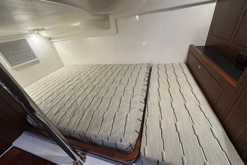 Wave Paver Yacht Photos Pics 2020 Pursuit OS 355 Offshore cabin interior with twin beds and wooden cabinetry.