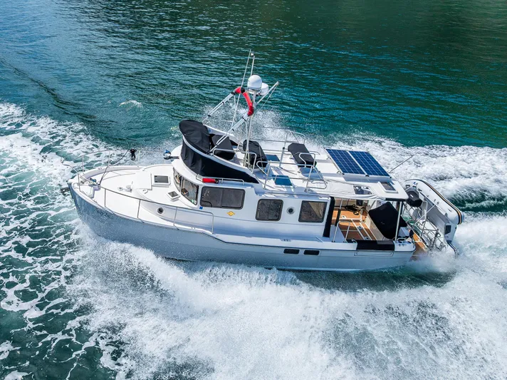 Salty Bliss Yacht Photos Pics 2021 Ranger Tugs R-31 CB cruising on water, showcasing sleek design and solar panels.