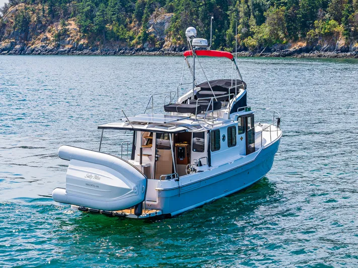 Salty Bliss Yacht Photos Pics 2021 Ranger Tugs R-31 CB boat on scenic water with lush green shoreline.