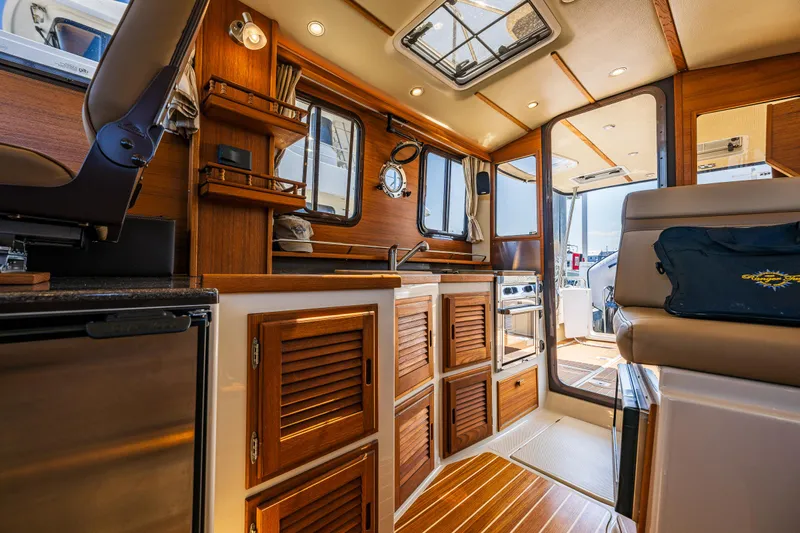 Salty Bliss Yacht Photos Pics Interior of 2021 Ranger Tugs R-31 CB, featuring wood cabinetry and modern amenities.