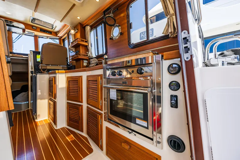 Salty Bliss Yacht Photos Pics Interior of 2021 Ranger Tugs R-31 CB with wood accents and modern appliances.