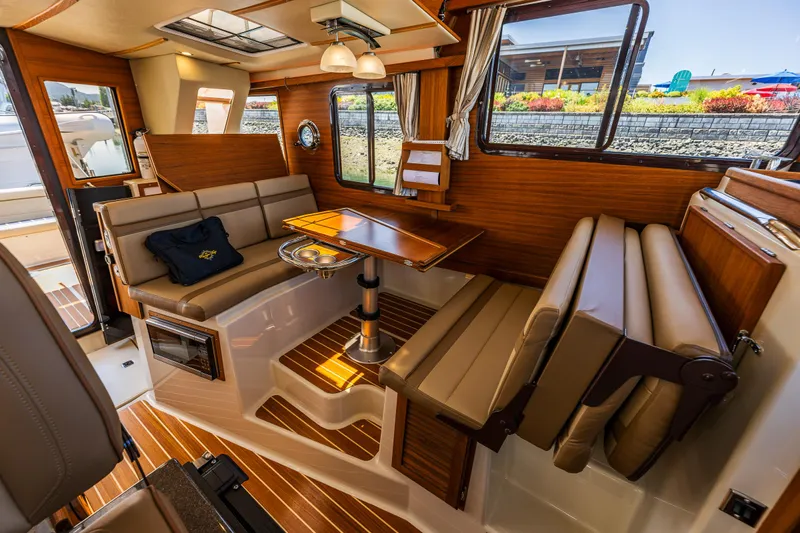 Salty Bliss Yacht Photos Pics 2021 Ranger Tugs R-31 CB interior with wood accents and seating area.
