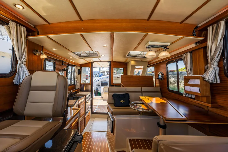 Salty Bliss Yacht Photos Pics Interior of 2021 Ranger Tugs R-31 CB, featuring elegant wood finishes and modern seating.