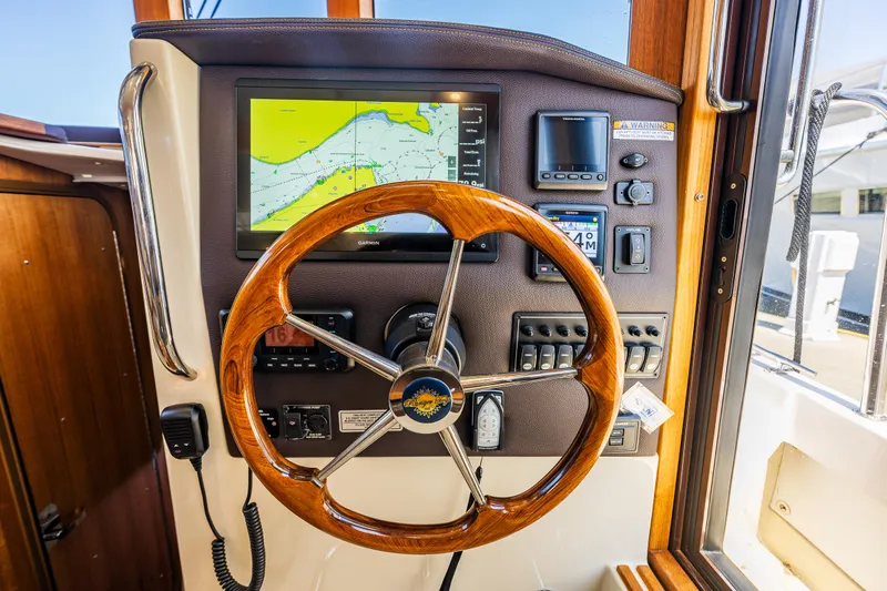 Salty Bliss Yacht Photos Pics 2021 Ranger Tugs R-31 CB helm with wooden steering wheel and navigation display.