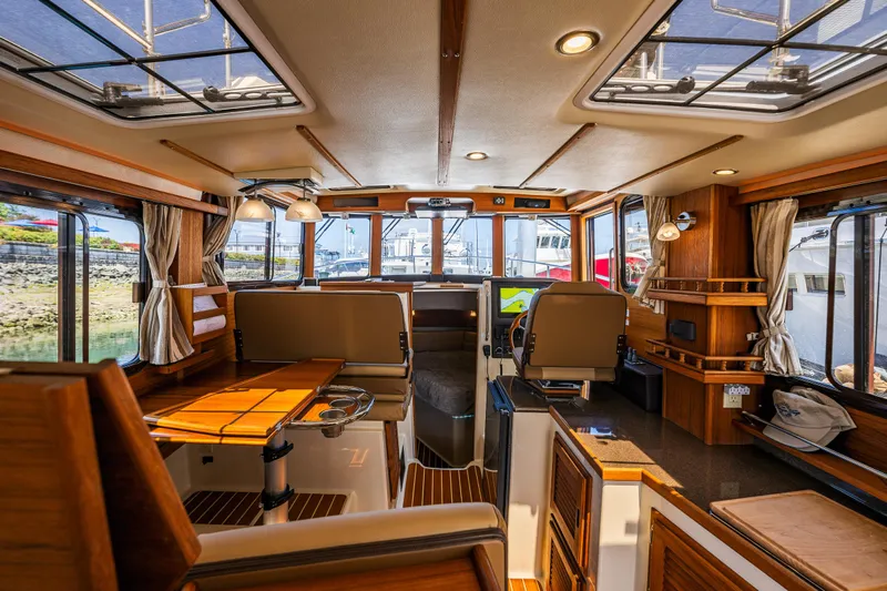 Salty Bliss Yacht Photos Pics Interior of 2021 Ranger Tugs R-31 CB, featuring elegant wood finishes and modern navigation equipment.