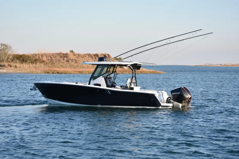  Yacht Photos Pics 2022 Blackfin 272 CC boat cruising on a calm lake with fishing rods.