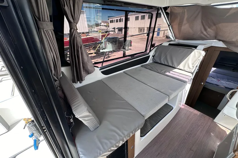 Pawsitive Attitude Yacht Photos Pics Interior of 2019 Jeanneau 895 boat with cushioned seating and large windows.