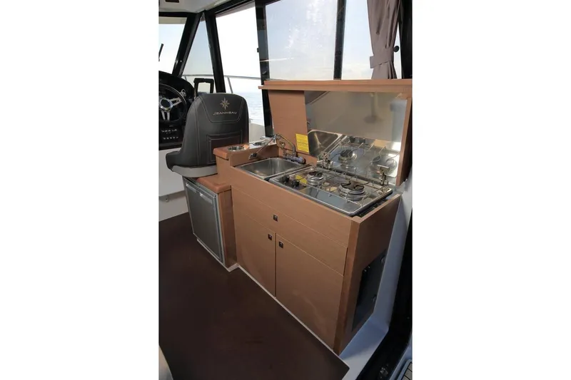 Pawsitive Attitude Yacht Photos Pics 2019 Jeanneau 895NC boat interior with compact kitchen and steering area.