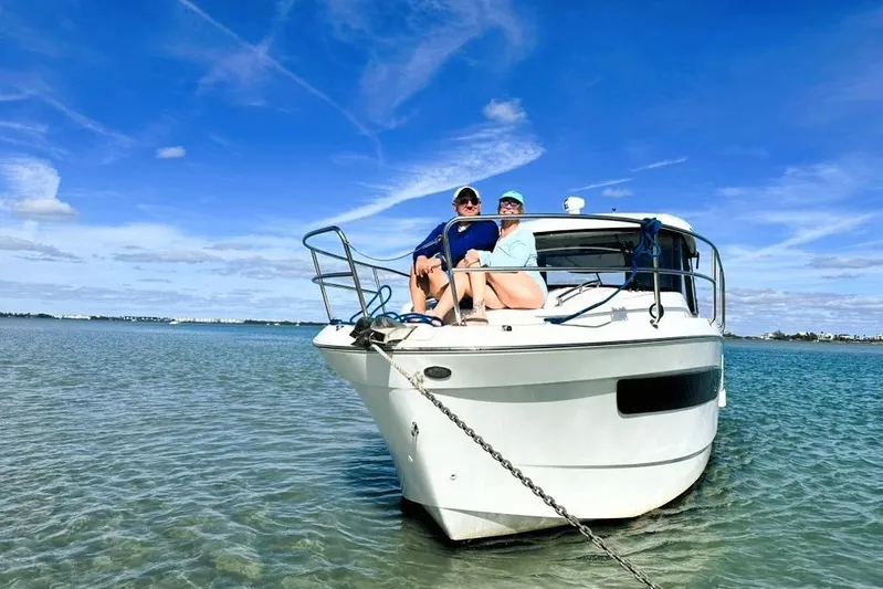 Pawsitive Attitude Yacht Photos Pics 2019 Jeanneau 895NC boat with two people relaxing on deck in sunny waters.