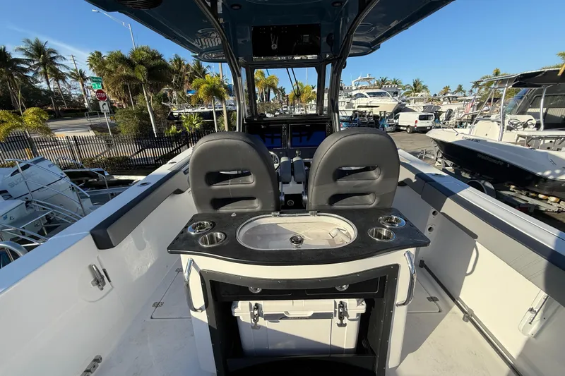  Yacht Photos Pics 2026 Sea Pro 292 DLX boat interior with helm, seating, and cup holders in a marina setting.