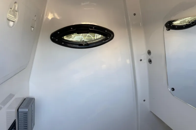  Yacht Photos Pics Interior view of 2026 Sea Pro 292 DLX boat cabin with porthole window.