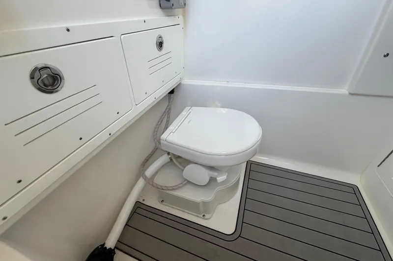  Yacht Photos Pics 2026 Sea Pro 292 DLX boat bathroom with toilet and storage compartments.