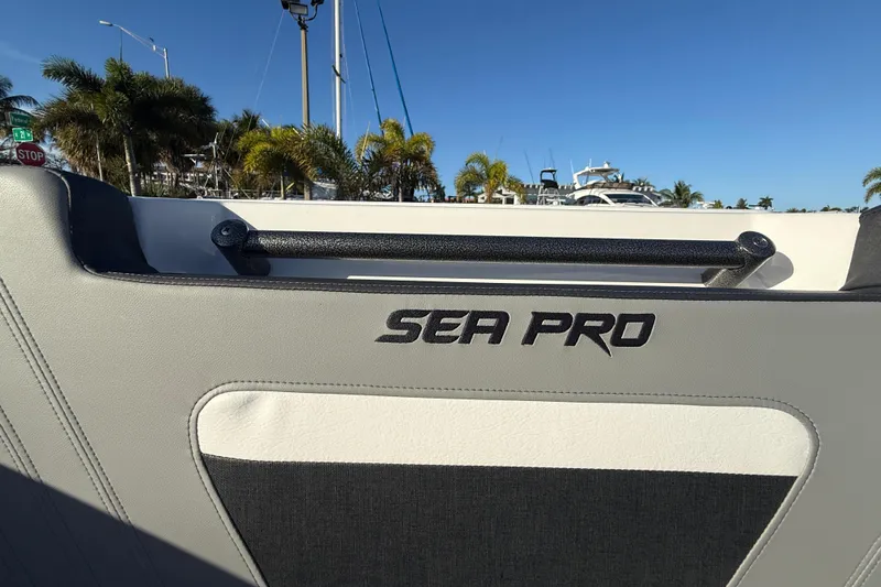  Yacht Photos Pics 2026 Sea Pro 292 DLX boat interior with logo, palm trees, and clear blue sky.
