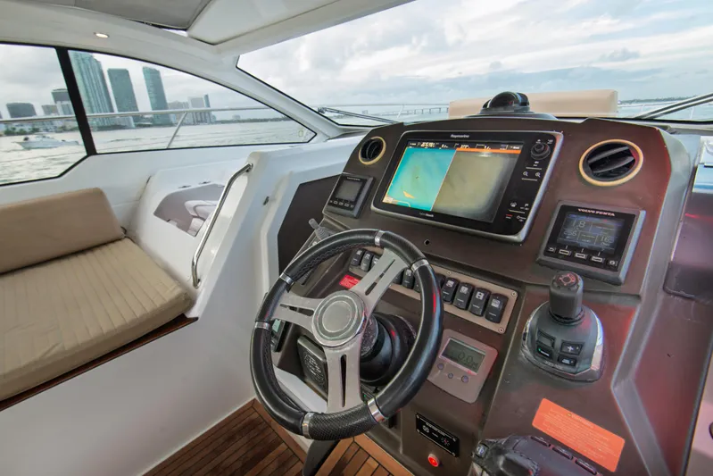  Yacht Photos Pics Cockpit of 2016 Azimut Atlantis 43 yacht with navigation controls and city skyline view.