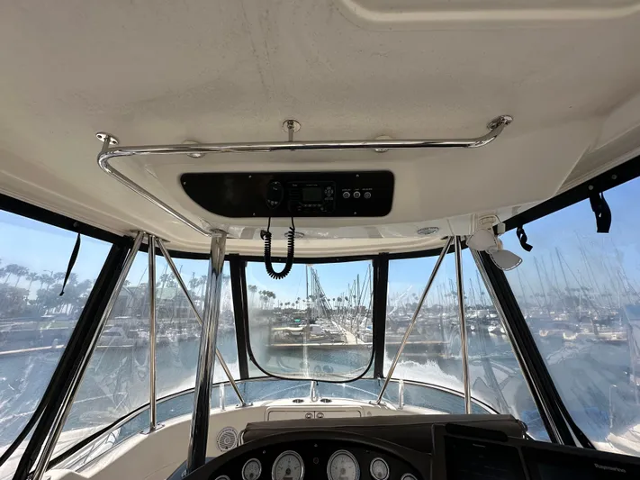 Euphoria Yacht Photos Pics Interior view of 2003 Riviera 37 Flybridge yacht cockpit with marina in background.