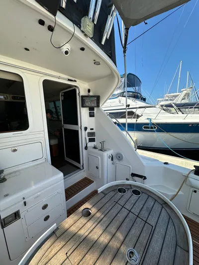 Euphoria Yacht Photos Pics 2003 Riviera 37 Flybridge yacht interior with wooden deck and marina view.