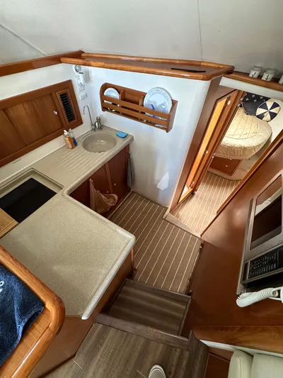 Euphoria Yacht Photos Pics Interior of 2003 Riviera 37 Flybridge yacht with kitchen and cozy bedroom.