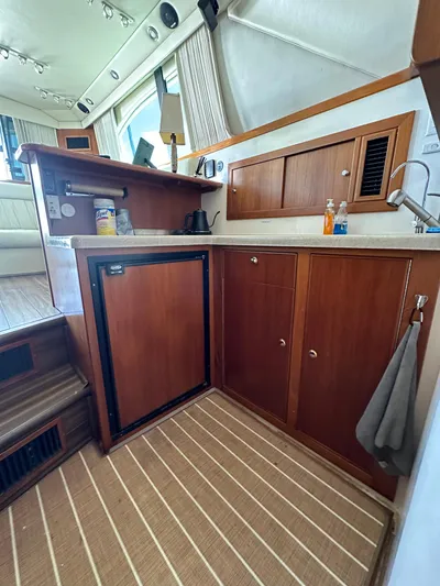 Euphoria Yacht Photos Pics 2003 Riviera 37 Flybridge yacht interior with wooden cabinetry and compact kitchen area.