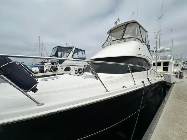 Euphoria Yacht Photos Pics 2003 Riviera 37 Flybridge yacht docked at marina under cloudy sky.