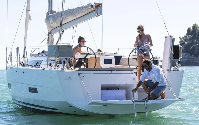  Yacht Photos Pics 2022 Dufour 390 Grand Prix sailboat with people enjoying a sunny day on the water.