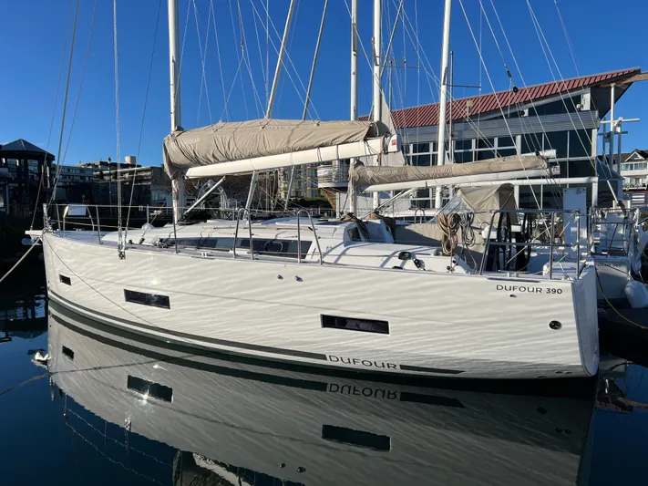  Yacht Photos Pics 2022 Dufour 390 Grand Prix sailboat docked in marina, reflecting on calm water.