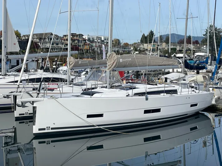  Yacht Photos Pics 2022 Dufour 390 Grand Prix sailboat docked in marina, reflecting on calm water.