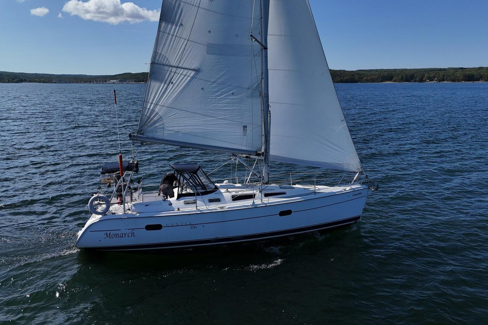 Sailing yacht "Monarch" on open water, Hunter 356 model, 2003, under clear blue sky.