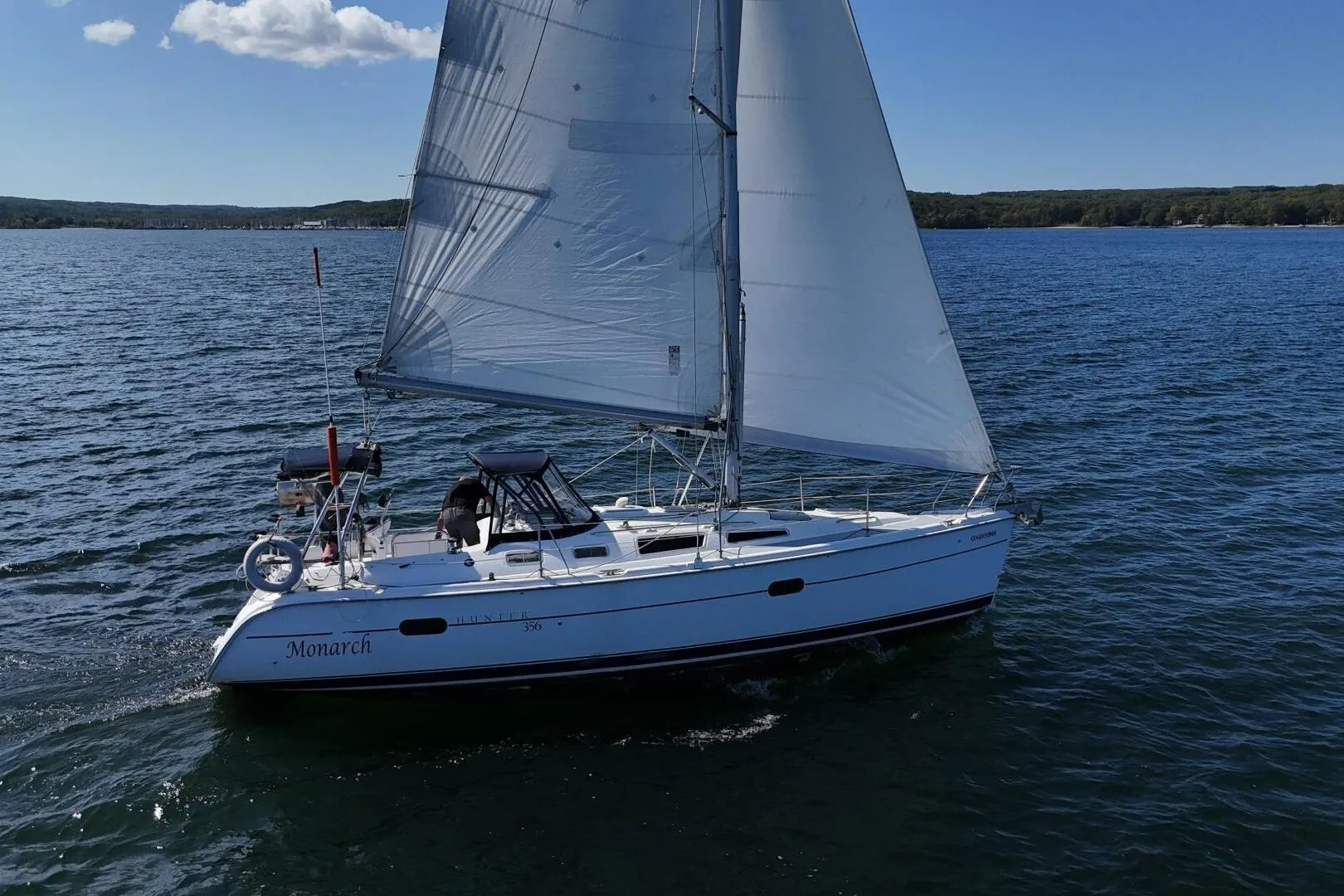 Sailing yacht "Monarch" on open water, Hunter 356 model, 2003, under clear blue sky.