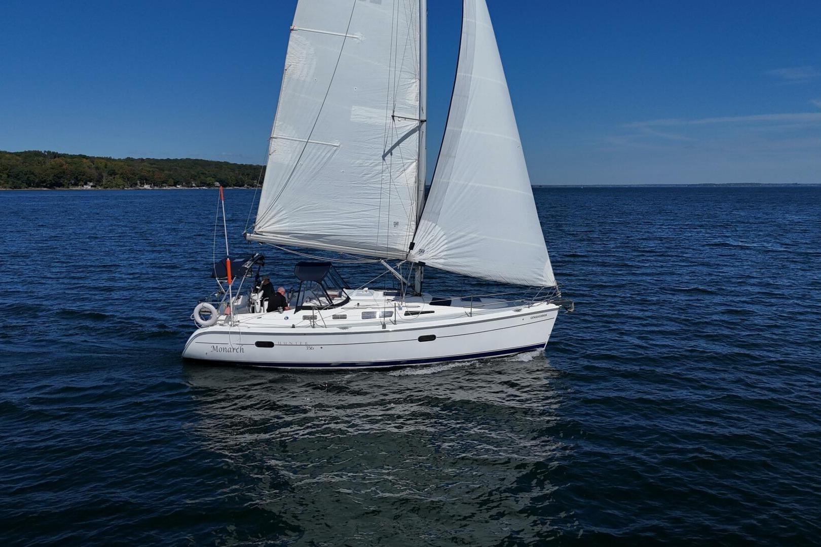 Sailboat "Monarch" on open water, Hunter 356 model, 2003, under clear blue sky.