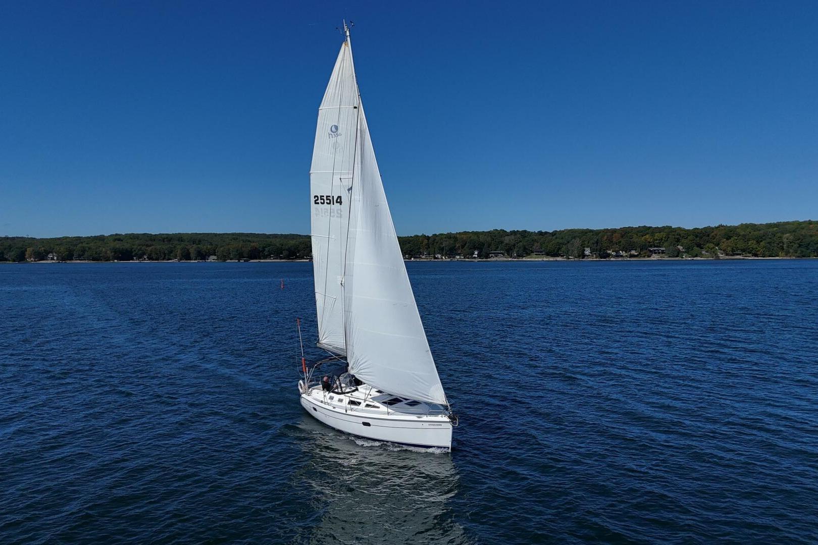 Sailboat on a lake, 2003 Hunter 356, cruising under clear blue skies.
