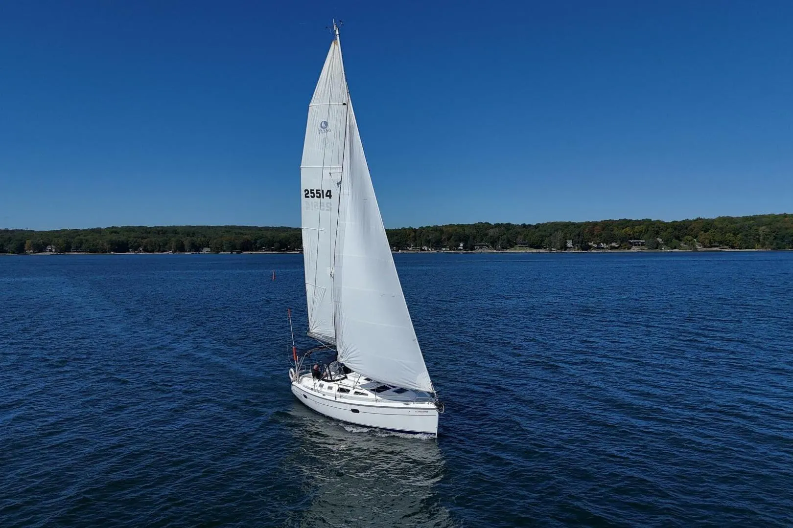 Sailboat on a lake, 2003 Hunter 356, cruising under clear blue skies.