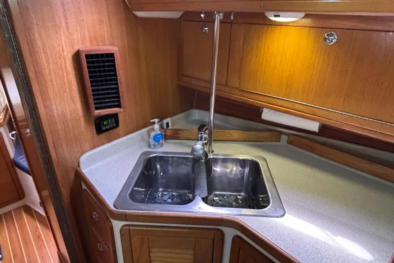  Yacht Photos Pics 2006 Catalina 42 MkII yacht kitchen with stainless steel sink and wooden cabinetry.
